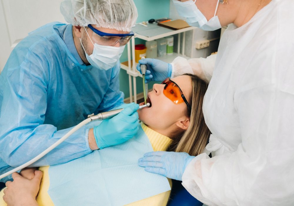 a-male-dentist-with-dental-tools-drills-the-teeth-of-a-patient-with-an-assistant-the-concept-of.jpg a-male-dentist-with-dental-tools-drills-the-teeth-of-a-patient-with-an-assistant-the-concept-of.jpg