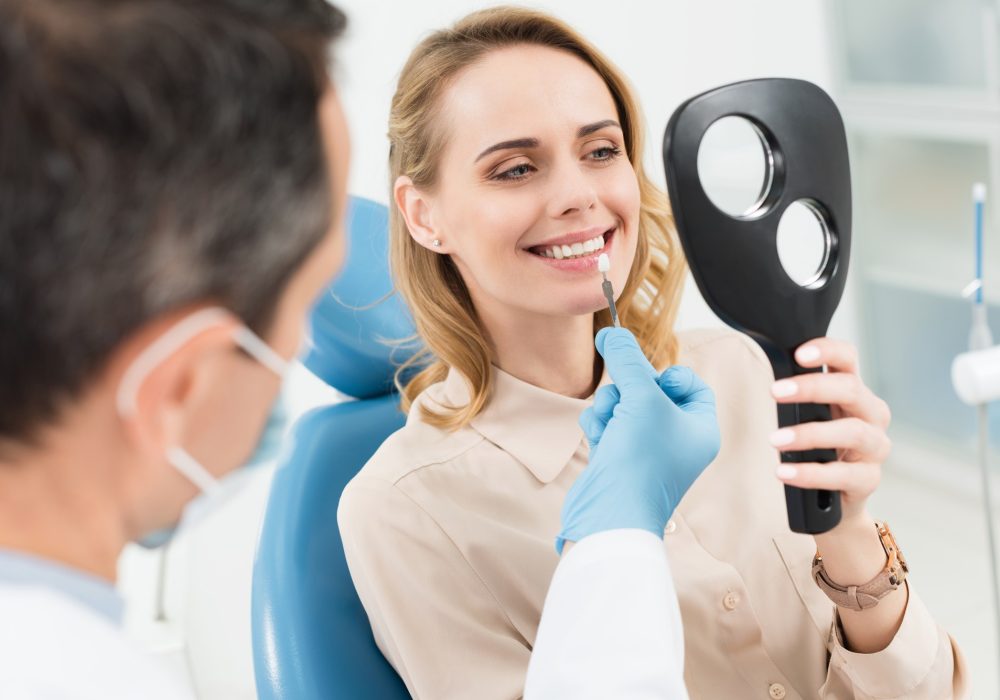 female-patient-choosing-tooth-implant-looking-at-mirror-in-modern-dental-clinic.jpg female-patient-choosing-tooth-implant-looking-at-mirror-in-modern-dental-clinic.jpg